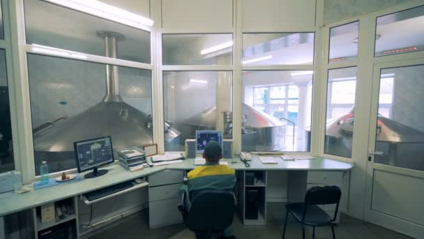 Чоловічий технік контролює процес виробництва спирту зі свого кабінету — стокове відео