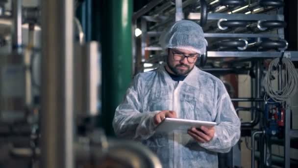 Trabalhador masculino está trabalhando em uma instalação de uma unidade de destilaria — Vídeo de Stock