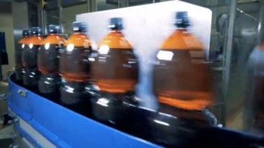 Konveyör bant ve bira şişeleri hızla birlikte taşınan bir dizi