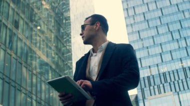 Gökdelenler işadamı bir tablet ile görünüyor, yakın çekim.