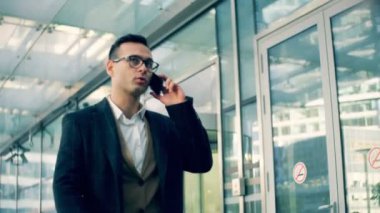 Meşgul Şirket Yöneticisi bir sokakta bir telefonda konuşur, yakın çekim.