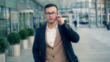 Meşgul Şirket Yöneticisi kesiminden bir sokakta, bir cep telefonu üzerinde konuşurken yakın çekim.
