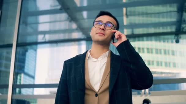 Een zakenman gesprekken over een telefoon, glimlachen, close-up. — Stockvideo