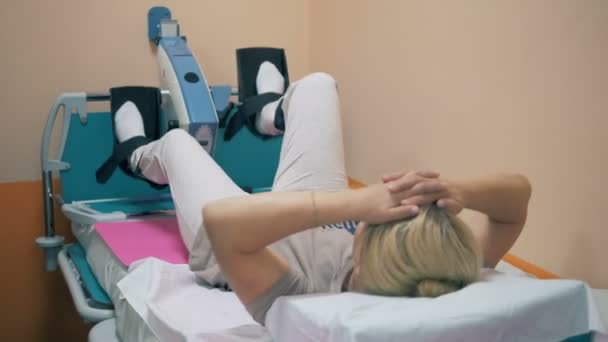 Una mujer girando las piernas en un dispositivo ortopédico, de cerca . — Vídeo de stock