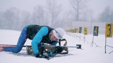 Bayan Biatlon atlet duruyor oturum çekim sonra yukarı. HD