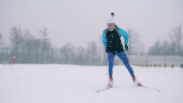 Russia, 05 marzo 2018, Processo di formazione sul biathlon. Vista frontale di un atleta di biathlon femminile che attraversa un terreno innevato — Video Stock