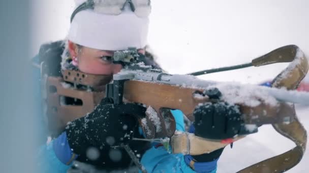 Desportista está atirando de seu rifle durante uma corrida de biatlo em uma posição deitada — Vídeo de Stock