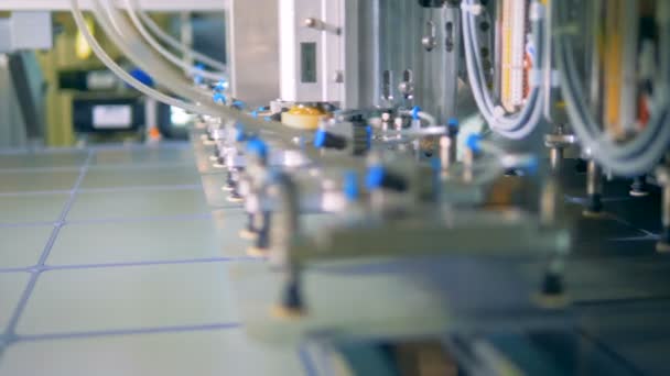Nahaufnahme von Reihen von Solarmodulzellen, die durch einen Mechanismus angehoben und auf das Förderband gelegt werden — Stockvideo