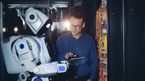 Técnico está ensinando um robô a usar e inspecionar servidores de computador — Vídeo de Stock