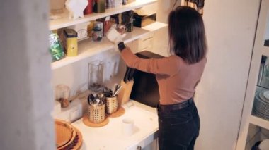 Genç kadın bir biyonik el ile bir kahve fincanı içine baharat ekler