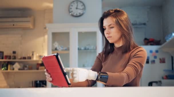 La computadora del comprimido está siendo operada por una chica con una mano protésica. — Vídeos de Stock