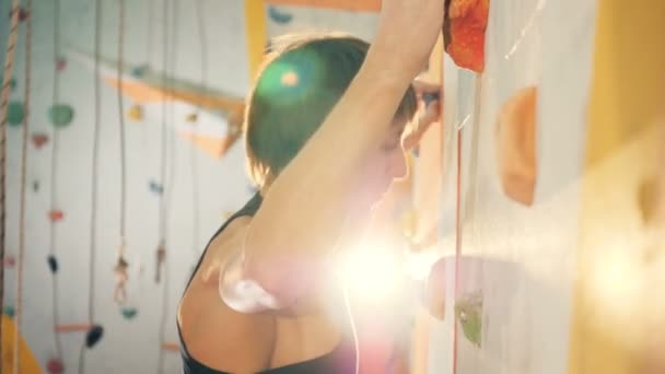 Vista lateral de um homem que se move ao longo da parede de escalada — Vídeo de Stock