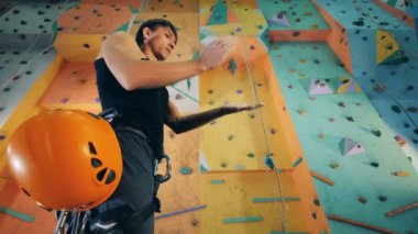 Bir adam bir spor salonu duvar tırmanma ve ellerini pudralanmaya için hazır Başlarken