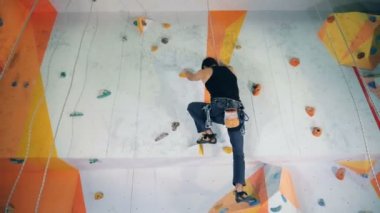 Ve dışarı yakınlaştırılmış bouldering duvara erkek dağcı