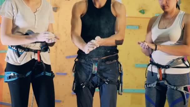 Two women and a man are powdering their hands before clambering training — Stock Video