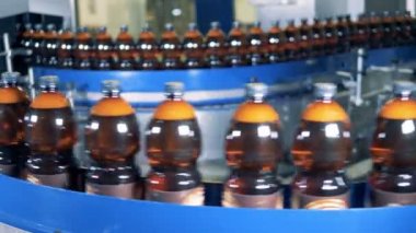 Bir fabrika konveyör şişe yakın çekim.