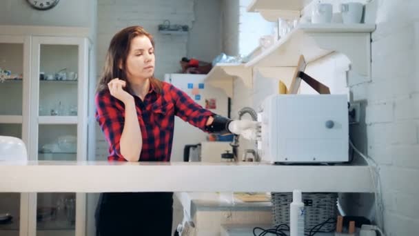 Una niña usando la mano protésica para sostener una taza, de cerca . — Vídeos de Stock