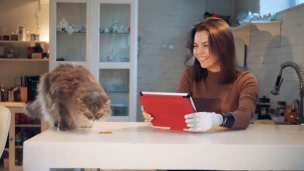 Jonge vrouw met een bionic hand en een kat in de buurt van haar — Stockvideo