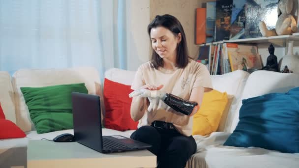 Una donna con protesi a mano su un computer portatile, da vicino . — Video Stock