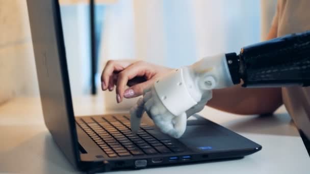 Person benutzt Roboterhand, um auf einem Laptop zu tippen, Nahaufnahme. — Stockvideo