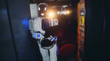 Elinde bir dizüstü bilgisayar ile bir sunucu odasına bir cyborg yürür, yakın çekim.