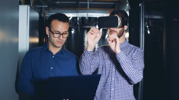 Un hombre lleva gafas VR en una sala de servidores, de cerca . — Vídeo de stock