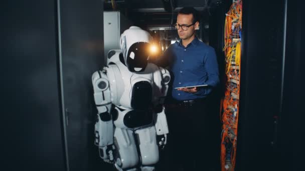 Un uomo accende un robot in un data center, da vicino . — Video Stock