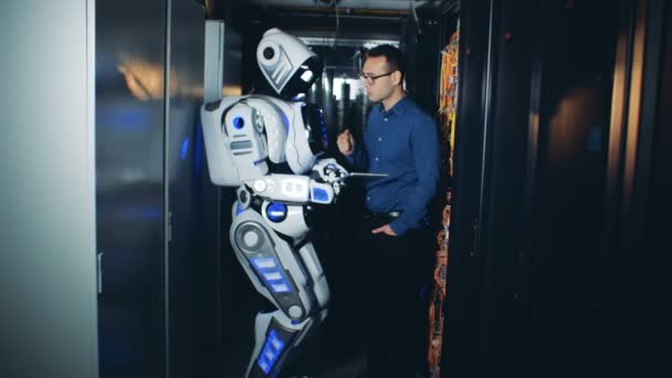 Människa och robot Kontrollera kablar på ett datacenter, närbild. — Stockvideo