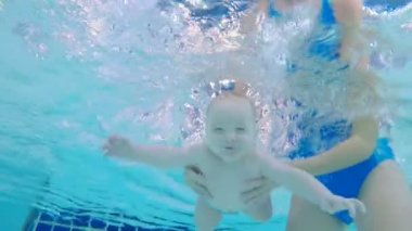 Bir yürümeye başlayan çocuk ve bir anne su altında bir havuzda yüzme kapat.