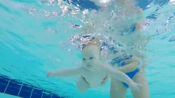Μωρό που προσπαθεί να κολυμπήσουν στην πισίνα, εσωτερικη. — Αρχείο Βίντεο