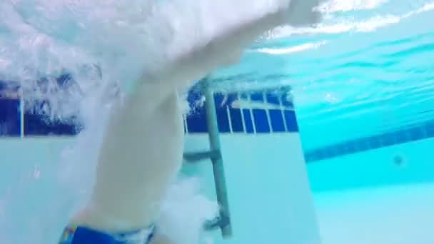 Kind stürzt in Pool ins Wasser. — Stockvideo