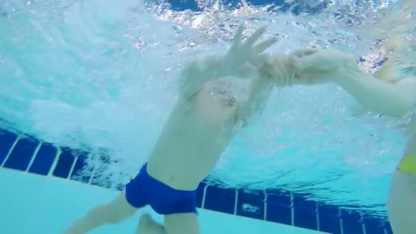 Uma criança tentando nadar debaixo d 'água em uma piscina, de perto . — Vídeo de Stock