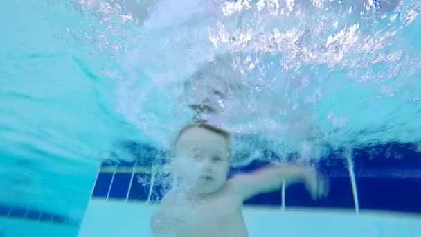 Mały chłopiec szkolenia pod wodą w basenie dla dzieci, z bliska. — Wideo stockowe