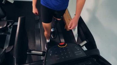 Protez bacak kesiminden bir koşu bandı üzerinde bir adamla yakın çekim.