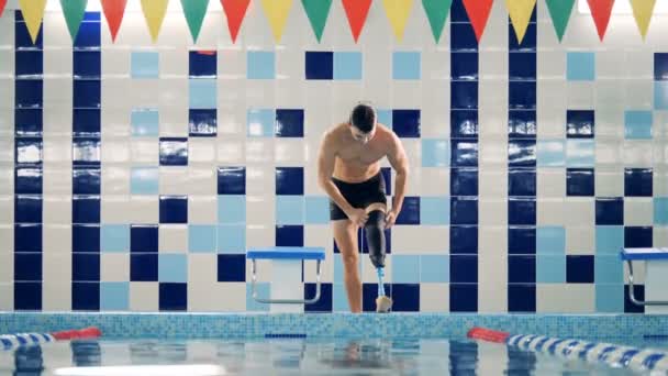 Swimmer fixes his leg prosthesis after swimming, close up. — Stock Video