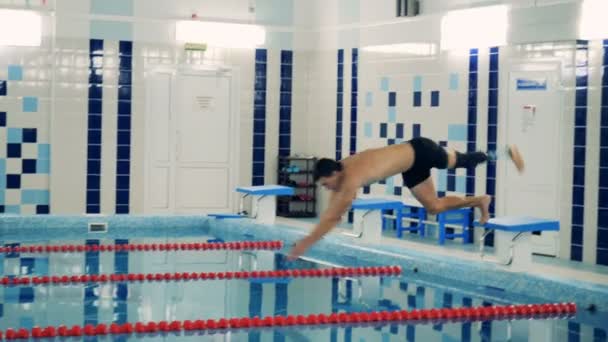 Professional swimmer workouts wearing a leg prosthesis, side view. — Stock Video