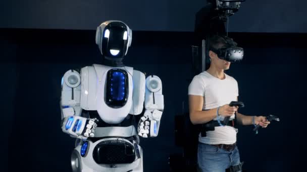Um jogador e robô na sala VR, vista lateral . — Vídeo de Stock