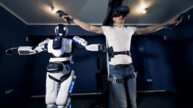 Genç adam çalış oyun VR ekipman ve robot, kullanarak, yakın çekim.