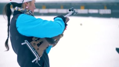 Biatlon tüfek ateş etmeye hazır bir kadın sporcu tarafından yeniden