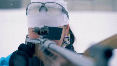Bayan atlet ateşli silah eğitimden Biatlon sırasında ateş ediyor