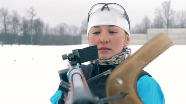 Snygg idrottskvinna drar en pärla från sitt gevär — Stockvideo