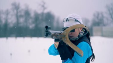 Kadın biatloncu onu amaçlayan sonra bir tüfek koyuyor