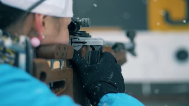Backside view of a sportswoman shooting on a biathlon stadium — Stock Video