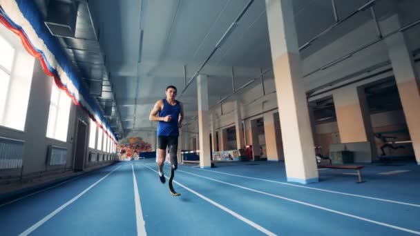 Um homem está correndo pelo ginásio com uma perna protética — Vídeo de Stock