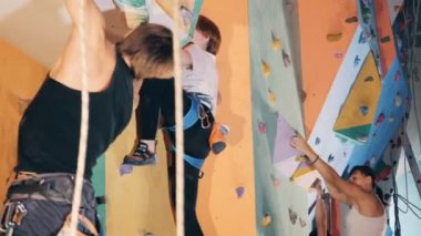 Kadın ve erkek bir duvar birlikte, yan görünüm üzerinde tırmanmaya.