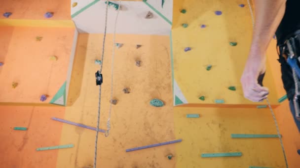 Male climber standing near a wall, back view. — Stock Video