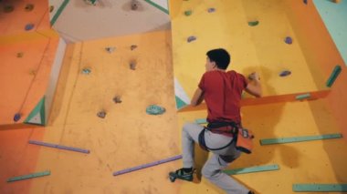 Bir kişi bir eğitim duvara atlar, kayalar, alt görünümü almıştır.