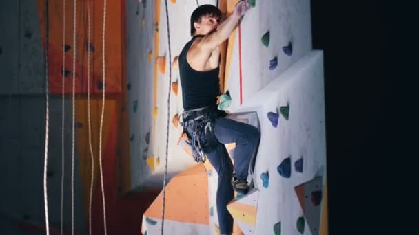 Professional climber going up on artificial wall, side view. — Stock Video