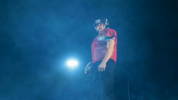 Американський футбол player пози на світлому фоні, нижній подання. — стокове відео