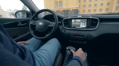 Bir adam, otururken otomatik pilotta bir otopark yakın çekim.